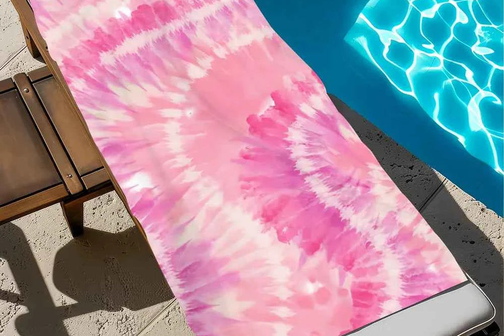 Pink tie-dye towel on a lounge chair by a pool